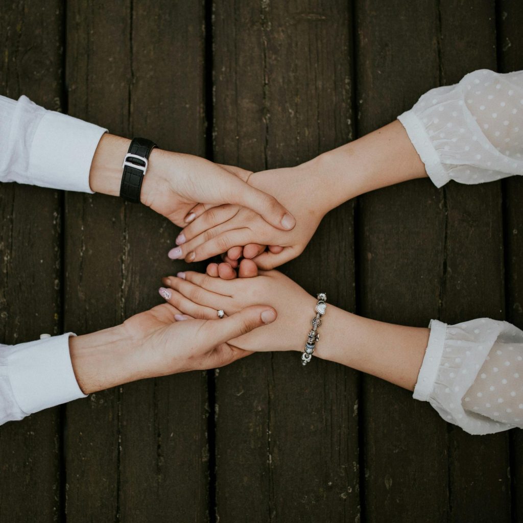 2 people joining hands together in solidarity